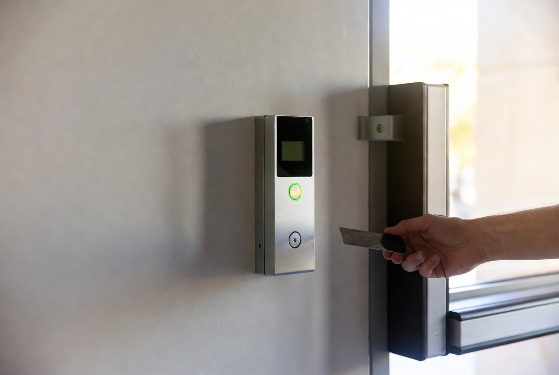 A wall-mounted access control reader beside a secured door