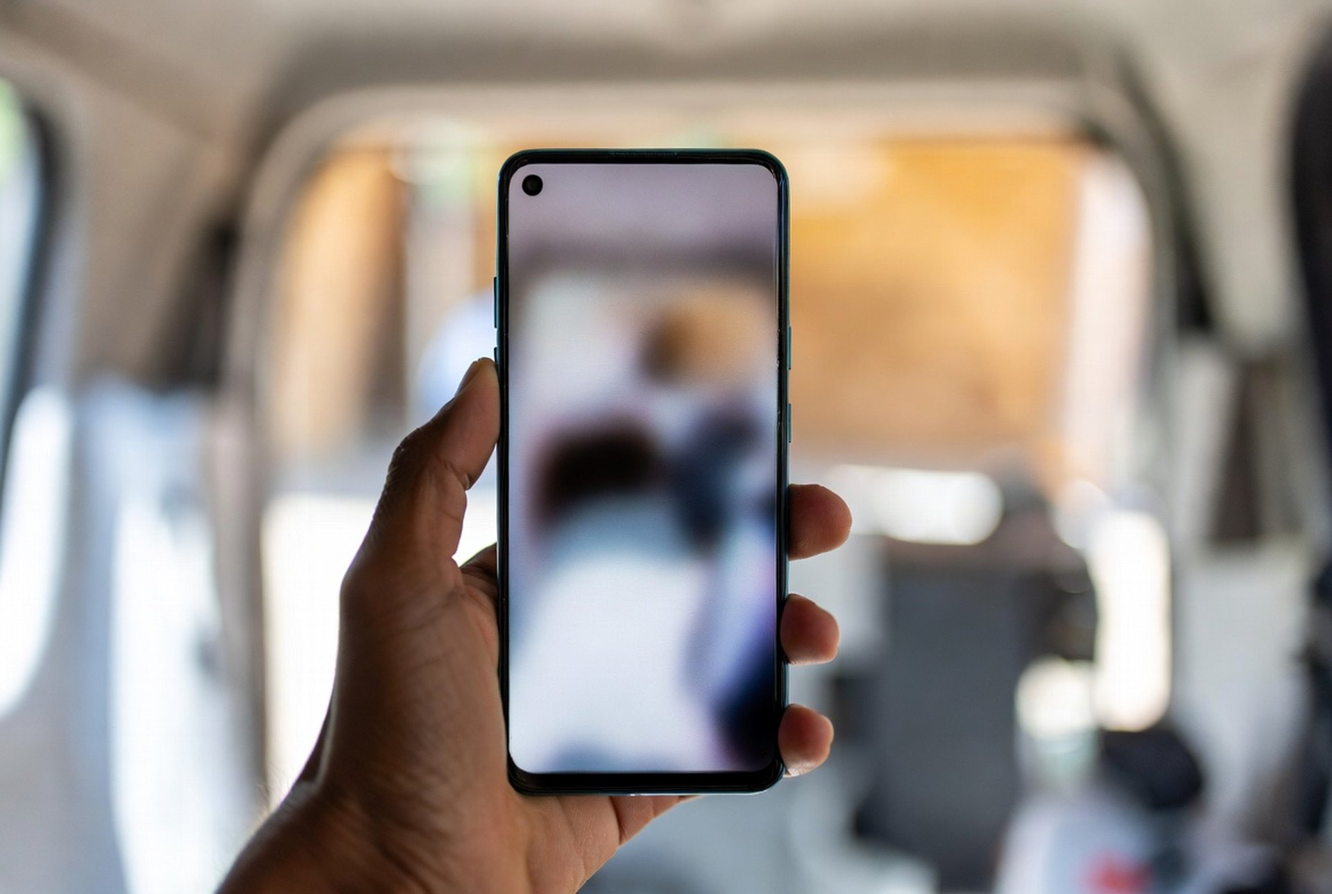 A smartphone showing a business call screen held in one hand