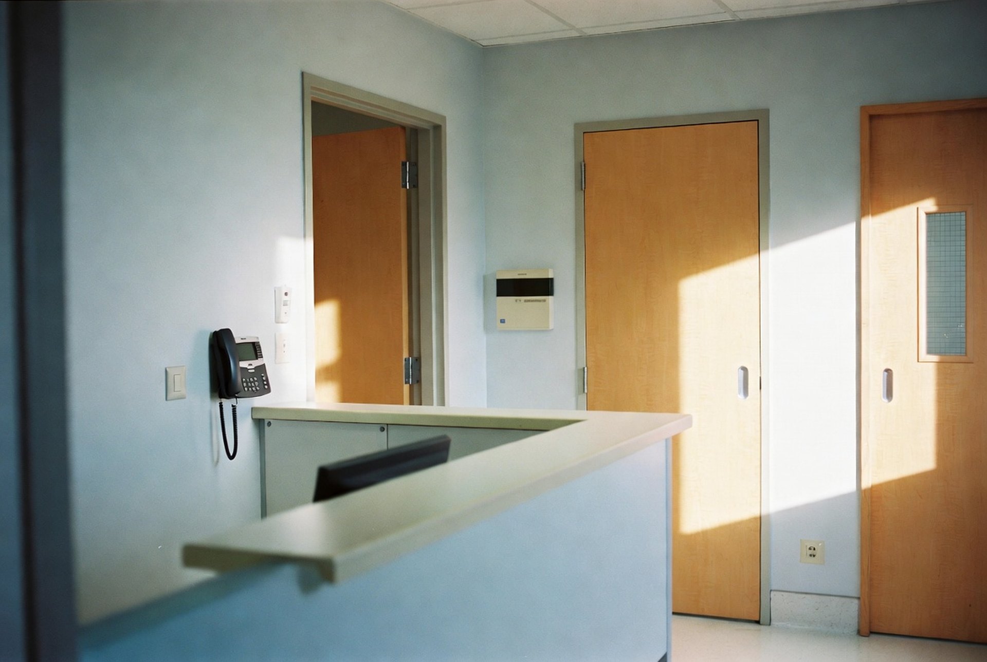 A clean medical clinic reception and corridor with a wall-mounted IP phone
