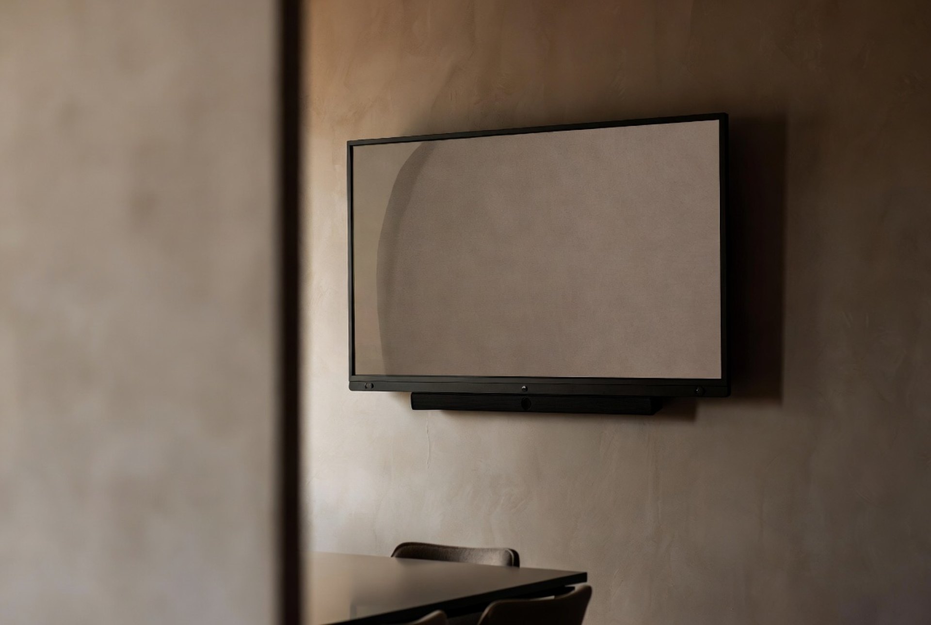 An empty modern meeting room with a wall display and video bar